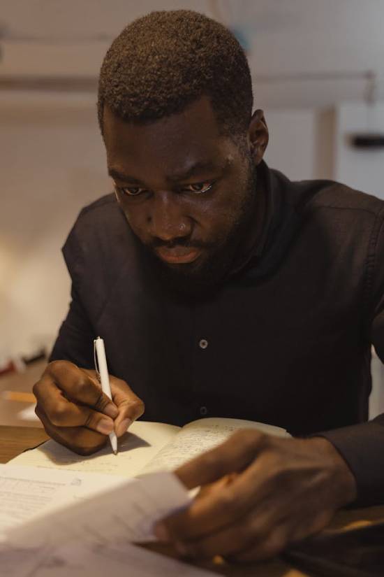 A man keeping track of his debt by writing it down in a journal