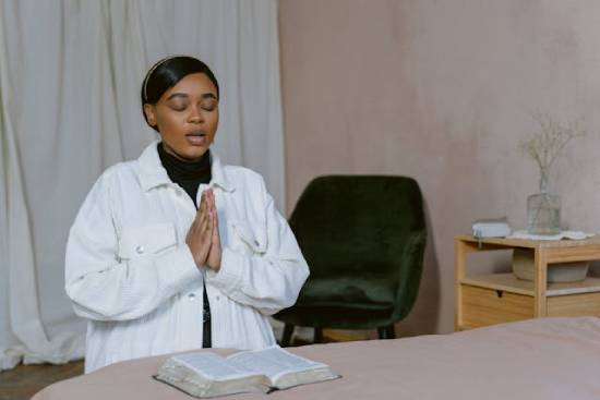 A woman praying with her Bible open shows how people can claim God's promises by faith.