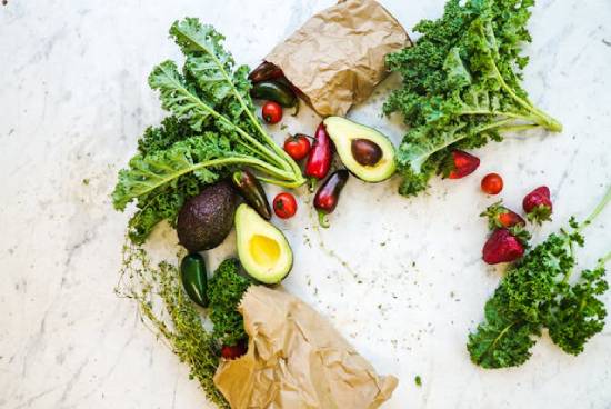 Bags filled with leafy greens, avocados, red berries, tomatoes, and peppers. These can provide vitamins.