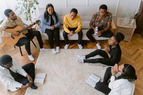 A family singing, studying Scriptures, and praying together as part of their daily morning devotion.