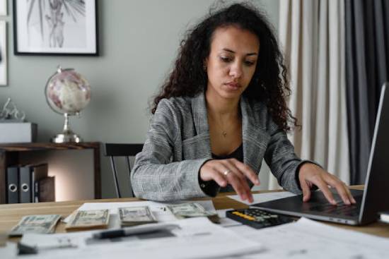 A woman tracking her income, expenses, and savings to know where everything goes and find any loopholes.