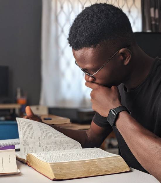 A young man studying the Bible to find insights on God's purpose for his life.