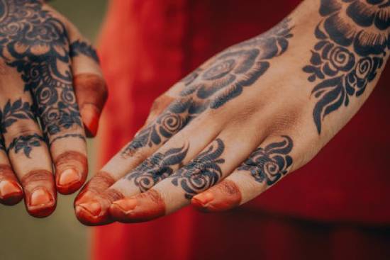 A woman's hands elaborately decorated with henna tattoos