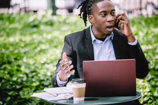Young businessman with a laptop and coffee outdoors