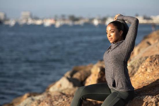A health-conscious woman keeping up with her fitness routine by the seashore.