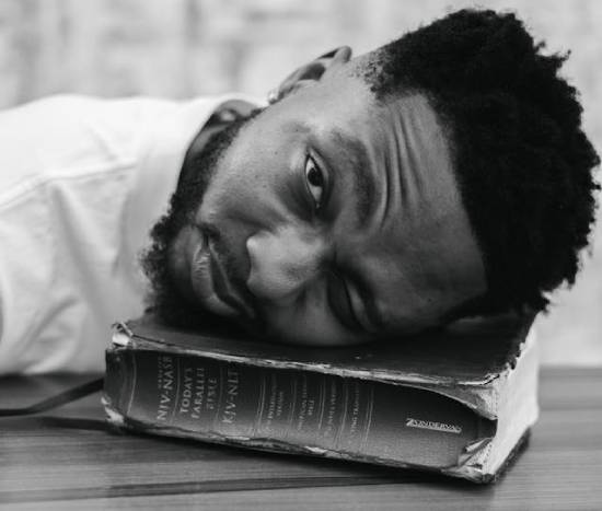 A man laying his head on a closed Bible, thinking about forgiveness.