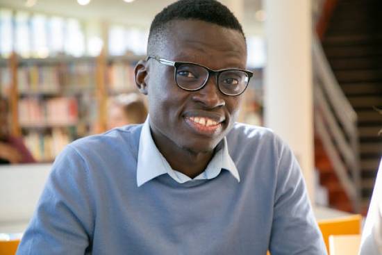 Smiling man in a library A man smiling as he studies in a library