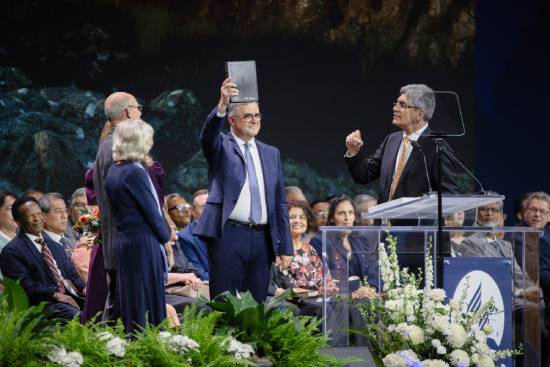 A spiritual leader lifting a Bible while teaching the congregants the principles of Sola Scriptura.