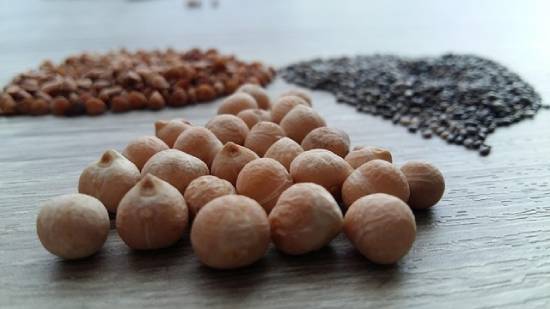 Legumes Spread on a Flat Surface Heaps of assorted legumes spread on a flat surface.
