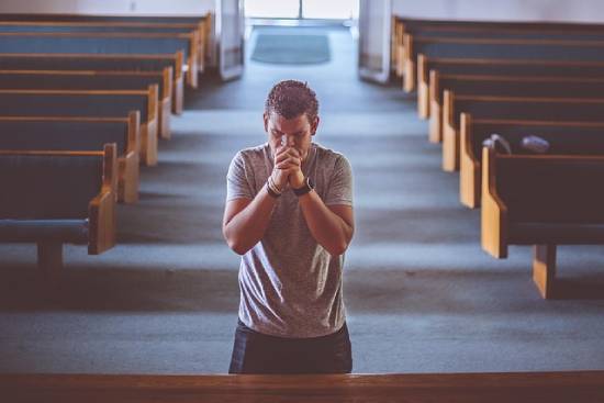 A Man Praying A man seeking God in prayer in a church.