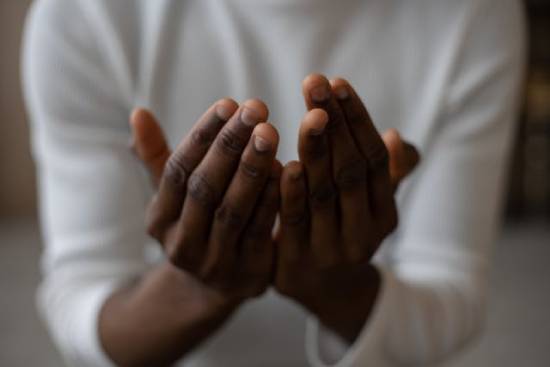 A Praying Man A man putting his hands together in reverence during a session of prayer.