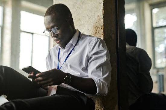 A Man Reading on a Cellphone A man reading about healing and God's forgiveness on his cellphone.
