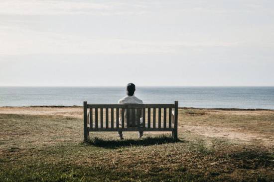 A single man sitting alone at the seashore. A single man sitting alone at the seashore.