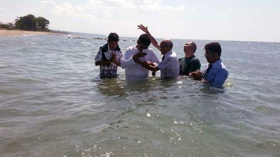 A Pastor Conducting Baptism A pastor baptising new converts to start a new journey with God.