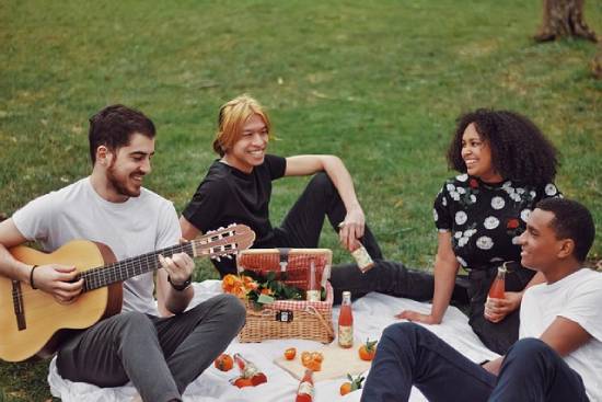 Friends Spending a Day Out Together Friends haning out together in a field,storyng, eating, and enjoying guiatr sounds.