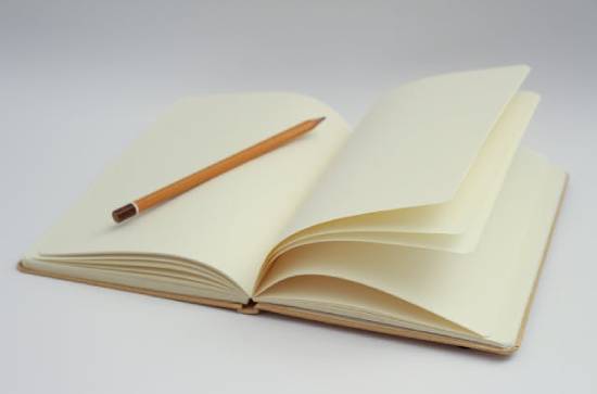 An Open Notebook and a Yellow Pencil A yellow pencil inside an open notebook symbolizing fresh opportunity to rewrite one's story.