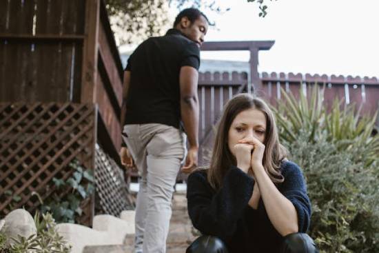 A Man Walking Away From a Woman A man walking away from a sad woman after struggling to solve their issues.