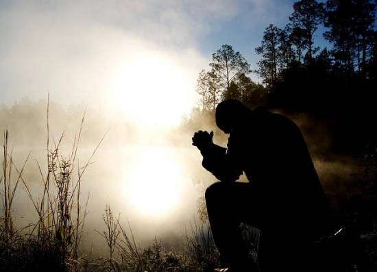 Silhouette of a Praying Man Silhouette of a praying man in a foggy neighborhood.