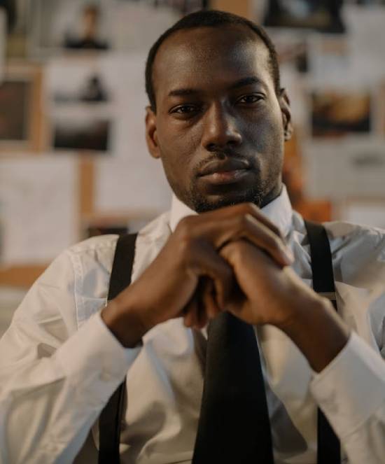 A Man in Deep Thoughts A man depressed in a white shirt, tie and suspenders in deep reflcetions on his desk.