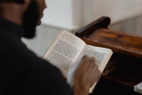 A Man Reading the Bible A man studying the Bible to discover the relationship between faith and stewardship.