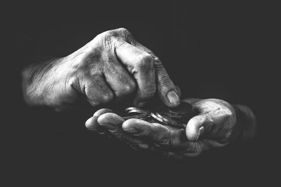 A Person Counting Coins A financially distressed person counting the few coins one by one.