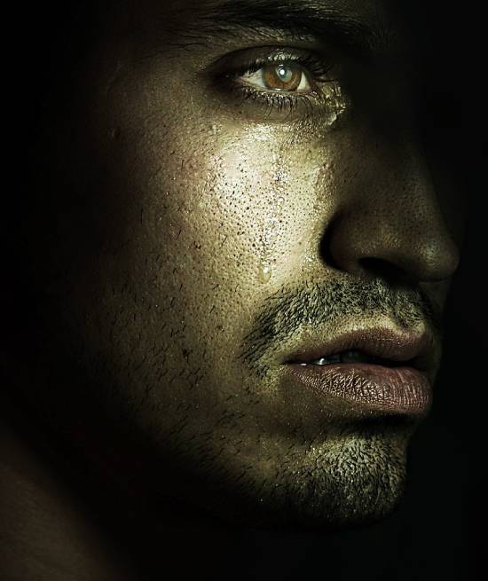 A Grieving Man A solem face of a sad man in tears and deep thoughts.