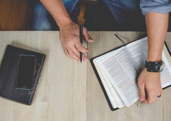 A personal studying the Bible an staking notes to understand what the Bible says about poverty and dependence on others.