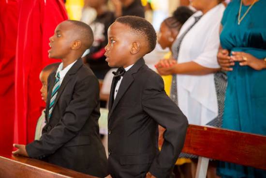 Boys at Church Service Two boys in elegant black suits attending a church service.