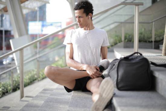 A man exercising while listening to a devotion using earphones.