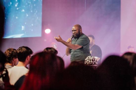 A Pastor Preaching Before Congregants A pastor in jungle-green t-shirt preaching before a congregation.