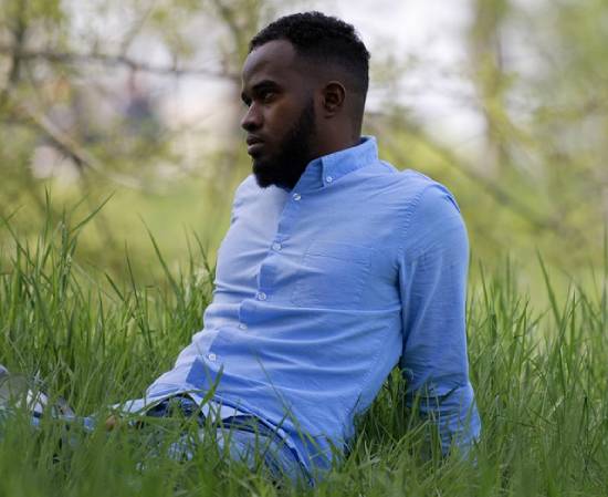 A Man Resting in a Park A man in a powder-blue shirt resting in a lush-green grass in a park.