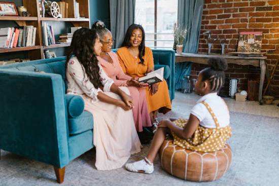 Women's Bible Study Three adult ladies having a Bible study in the living room while a little girl listens keenly.
