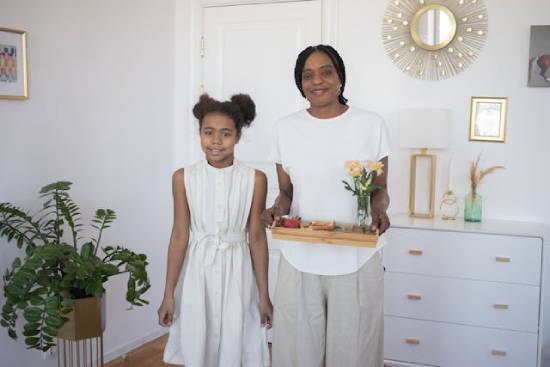 A mother and daughter standing side by side.