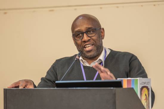 A man making a presentation on Christian self-care from a podium.
