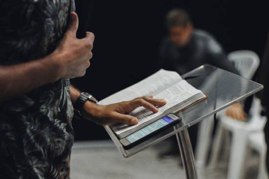 A clergy leading in a Bible study from the podium.
