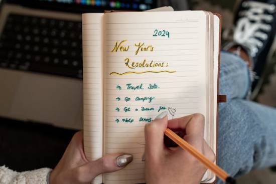 A person writing new years resolution in a notebook.