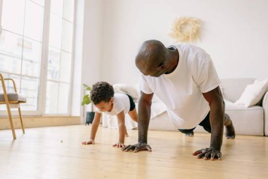 Father and Son Planking A father and son doing planks in the living room.