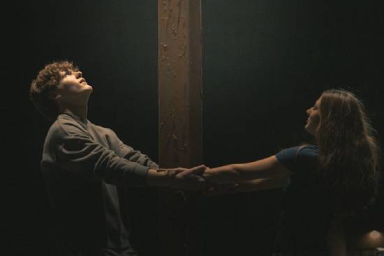 Couple Holding Hands Around a Wooden Beam A couple playing a relationship bonding game by holding hands around a wooden beam.