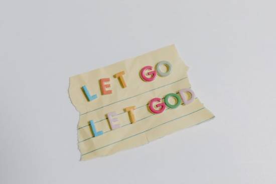 'Let go Let God' affirmation written on teared notebook.