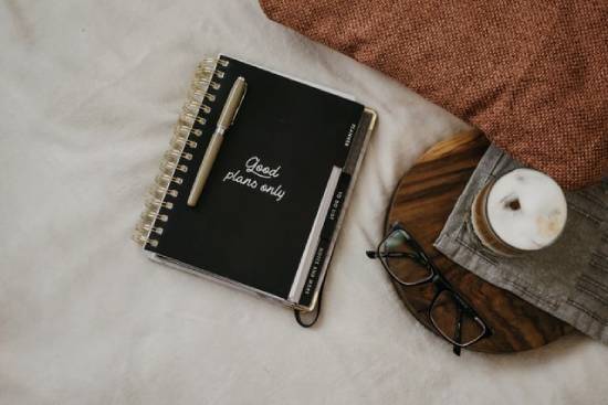 A lifeplan notebook and a pen placed beside eye glasses.